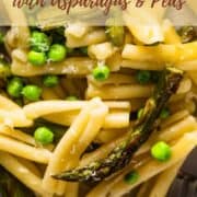close up shot of casarecce pasta with peas and asparagus and grated cheese on top