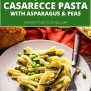 plate of casarecce pasta with asparagus, peas and grated cheese on top with a fork
