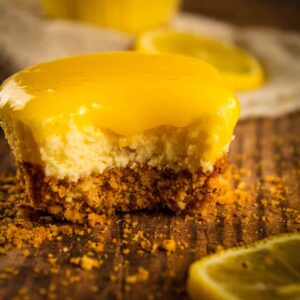 mini cheesecake topped with lemon curd with a bite taken from it