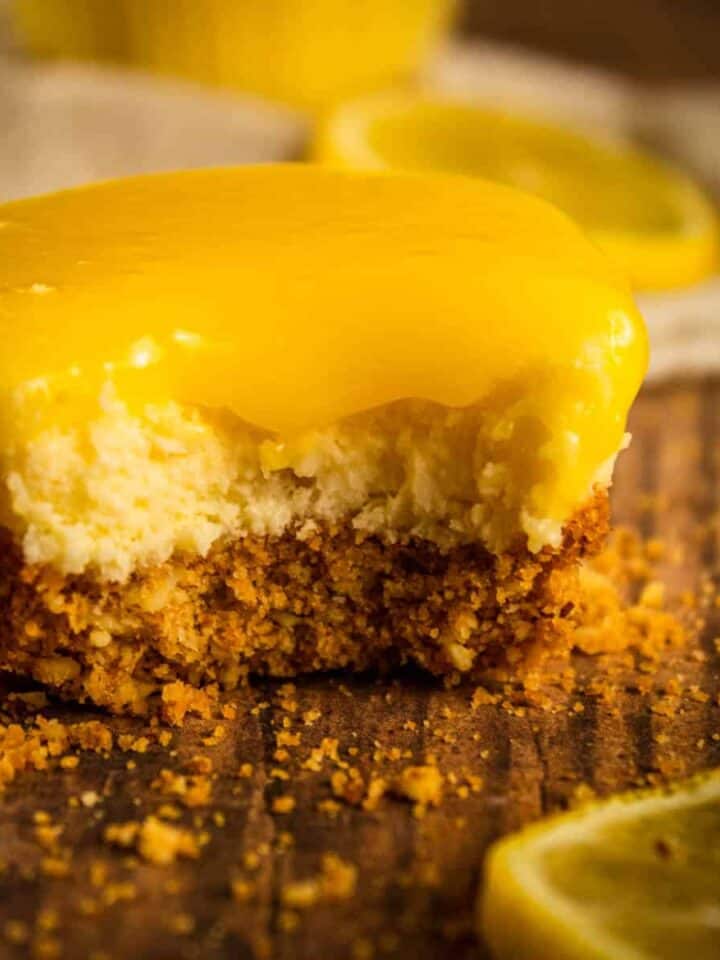 mini cheesecake topped with lemon curd with a bite taken from it
