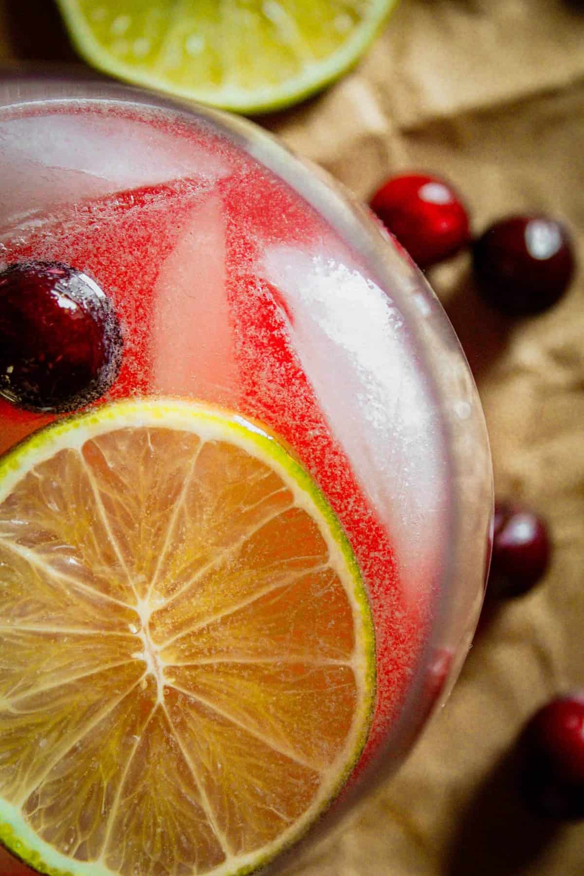 overhead shot of a cranberry moscow mule with ice, a slice of lime and fresh cranberry garnish