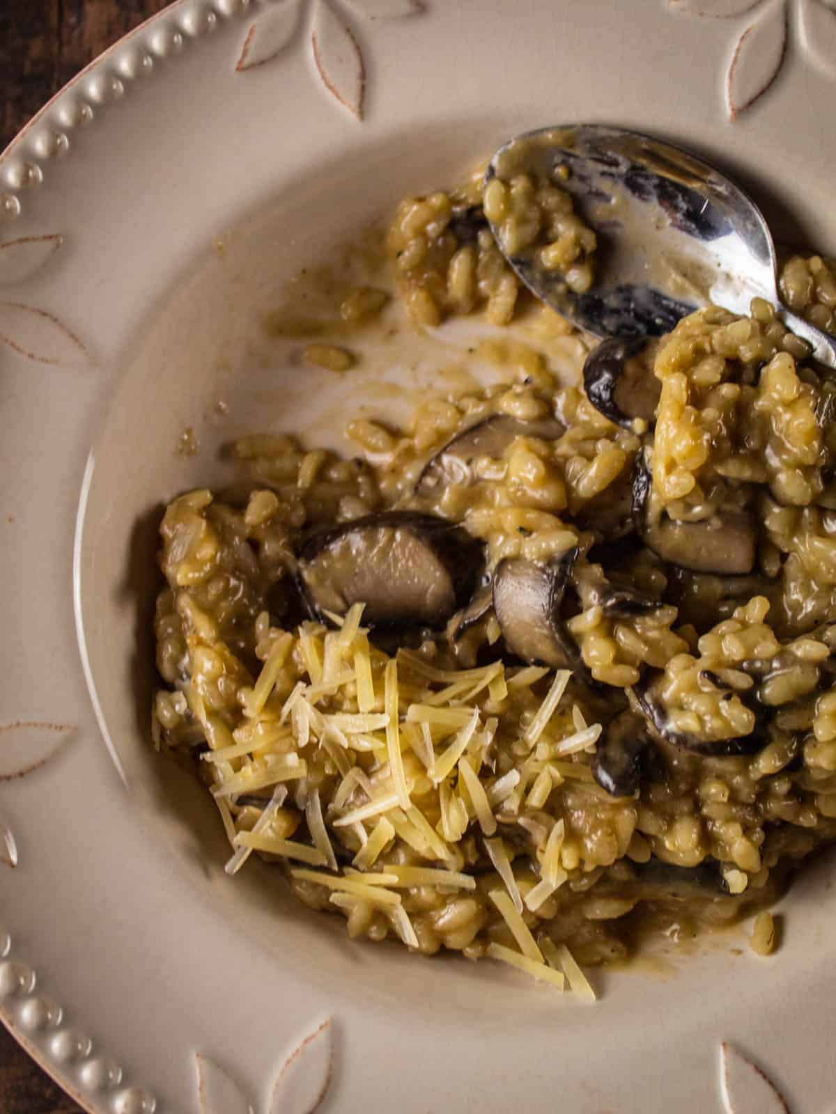 bowl of half eaten mushroom risotto with a spoon