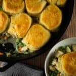 pot pie topped with biscuits in a cast irion skillet