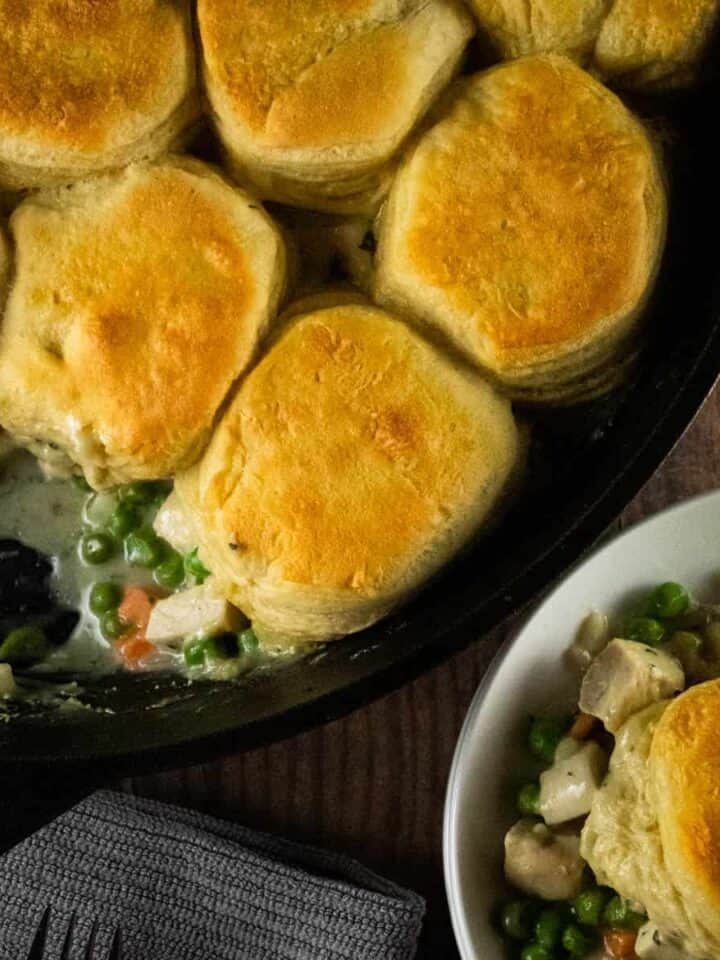 pot pie topped with biscuits in a cast irion skillet