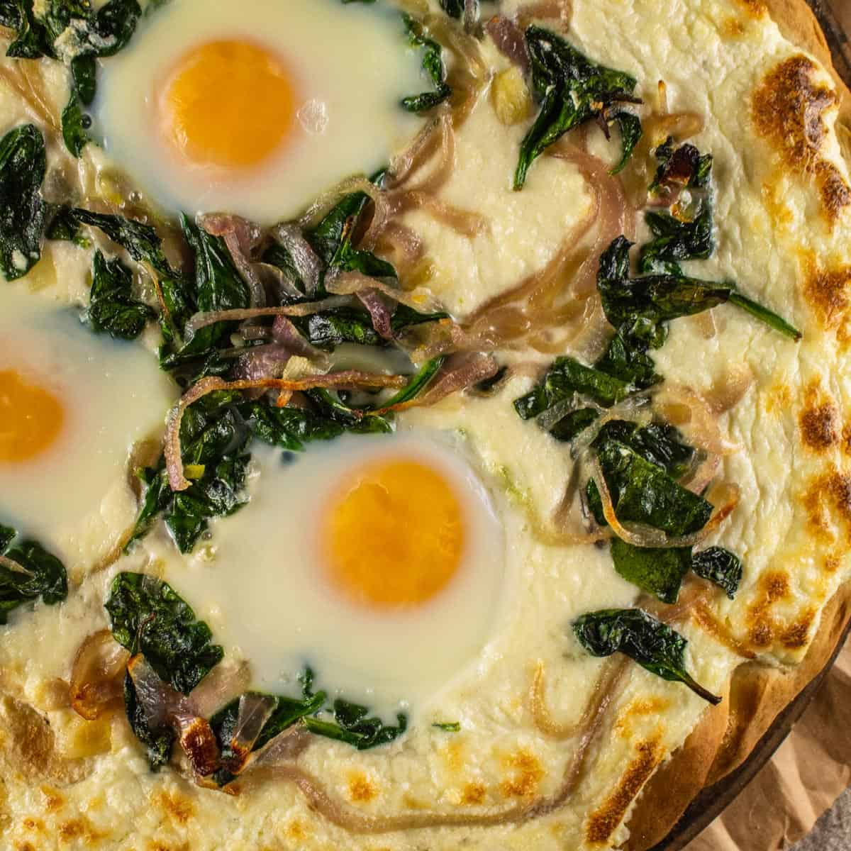 pizza with ricotta cheese, sauteed spinach and onions and baked eggs