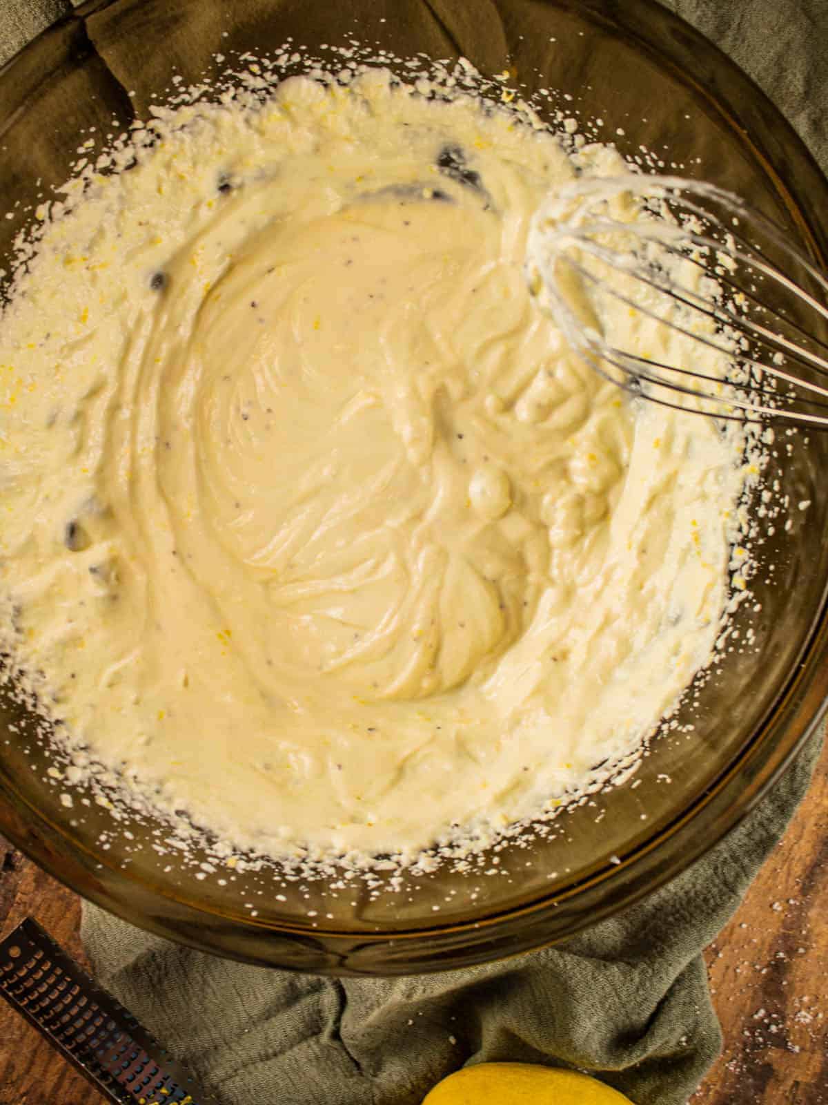 large glass mixing bowl filled with whipped ricotta