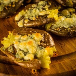 smashed red potato topped with browned blue cheese crumbles on a wooden tray