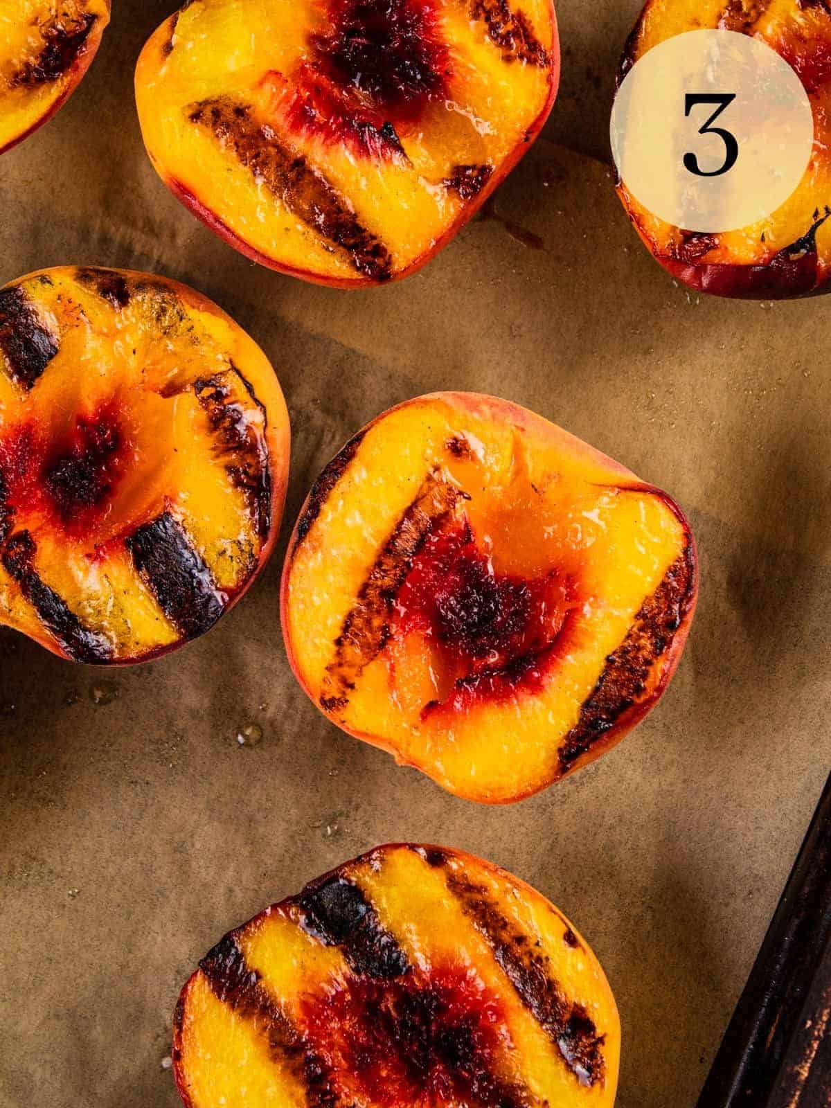 fresh peach halves with grill marks on them.