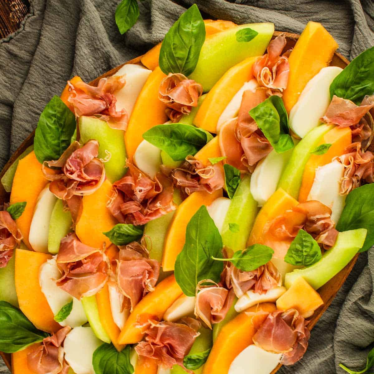 slices of honeydew and cantaloupe layered with mozzarella, fresh basil and prosciutto