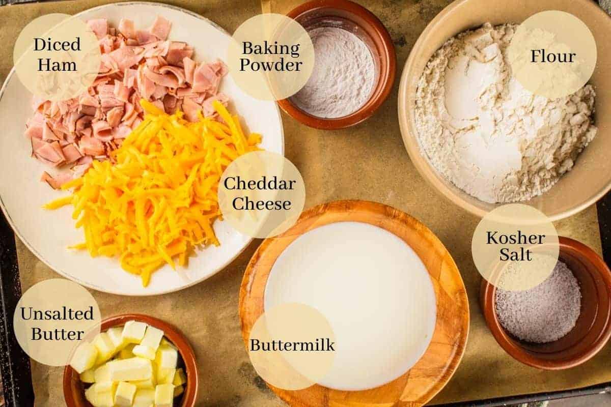 flour, baking powder, salt, buttermilk, butter, ham and cheese on a sheet pan