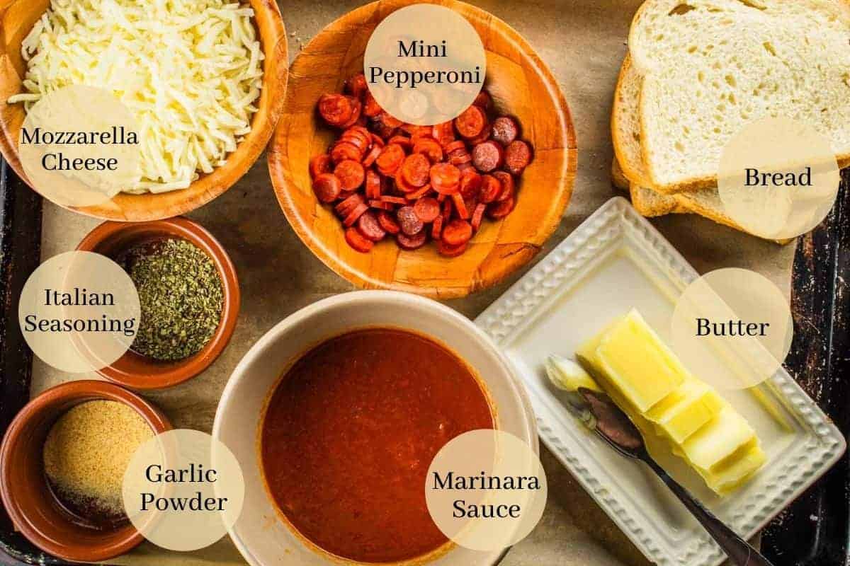 cheese, pepperoni, italian seasoning, garlic powder, marinara, butter and bread on a sheet pan