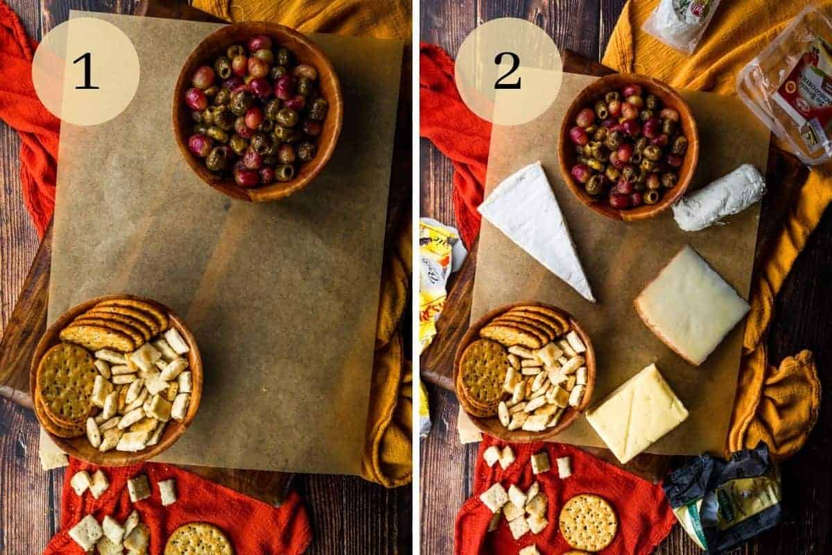 bowls of crackers and grapes and olives on a board with wedges and logs of cheese