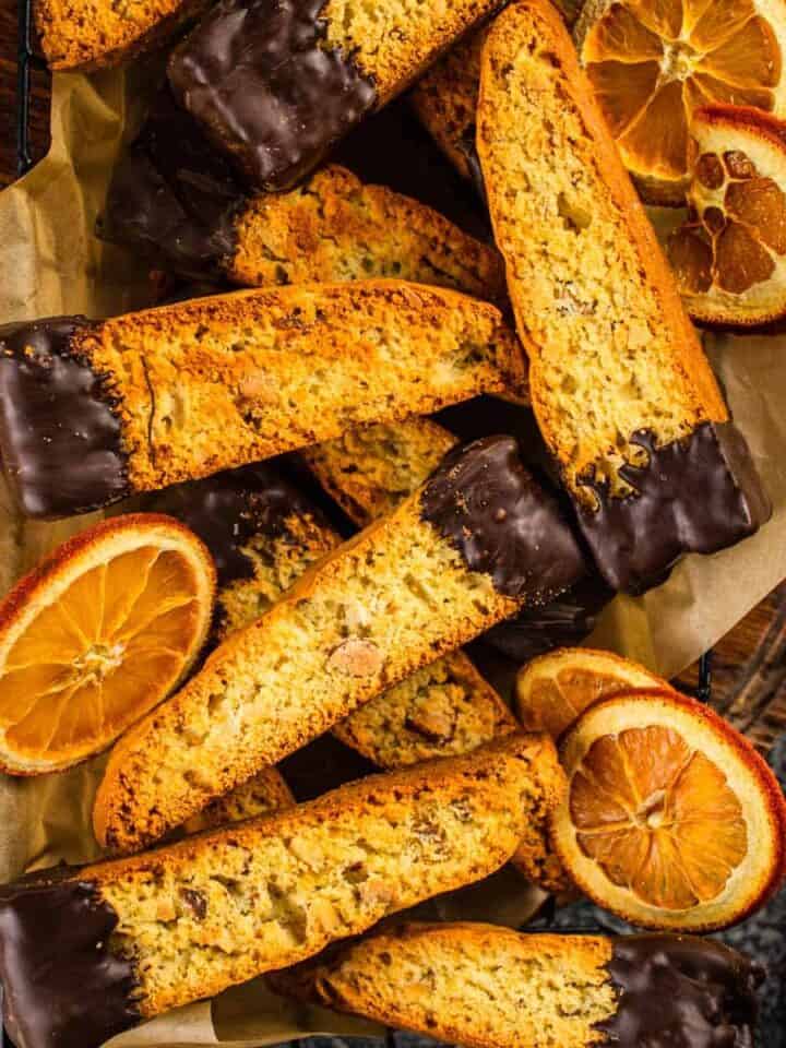 chocolate dipped biscotti in a basket with dried orange slices
