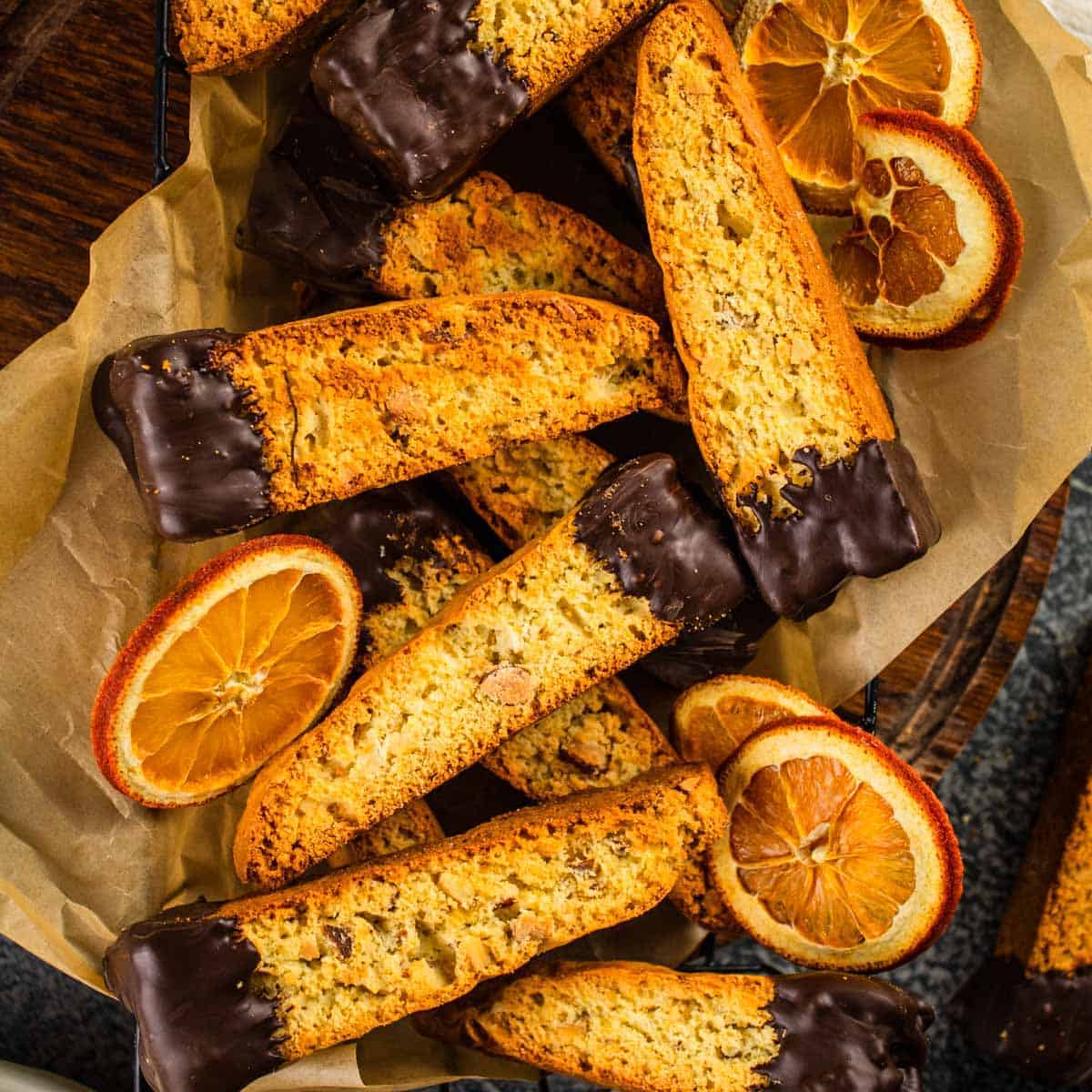 biscotti with chocolate dipped ends in a basket with dried orange slices