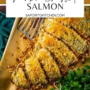 baked panko crusted salmon filet partially sliced on a sheet pan with a metal spatula