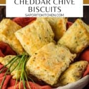rectangle cheddar chive biscuits in a basket with fresh chives and a rust colored napkin