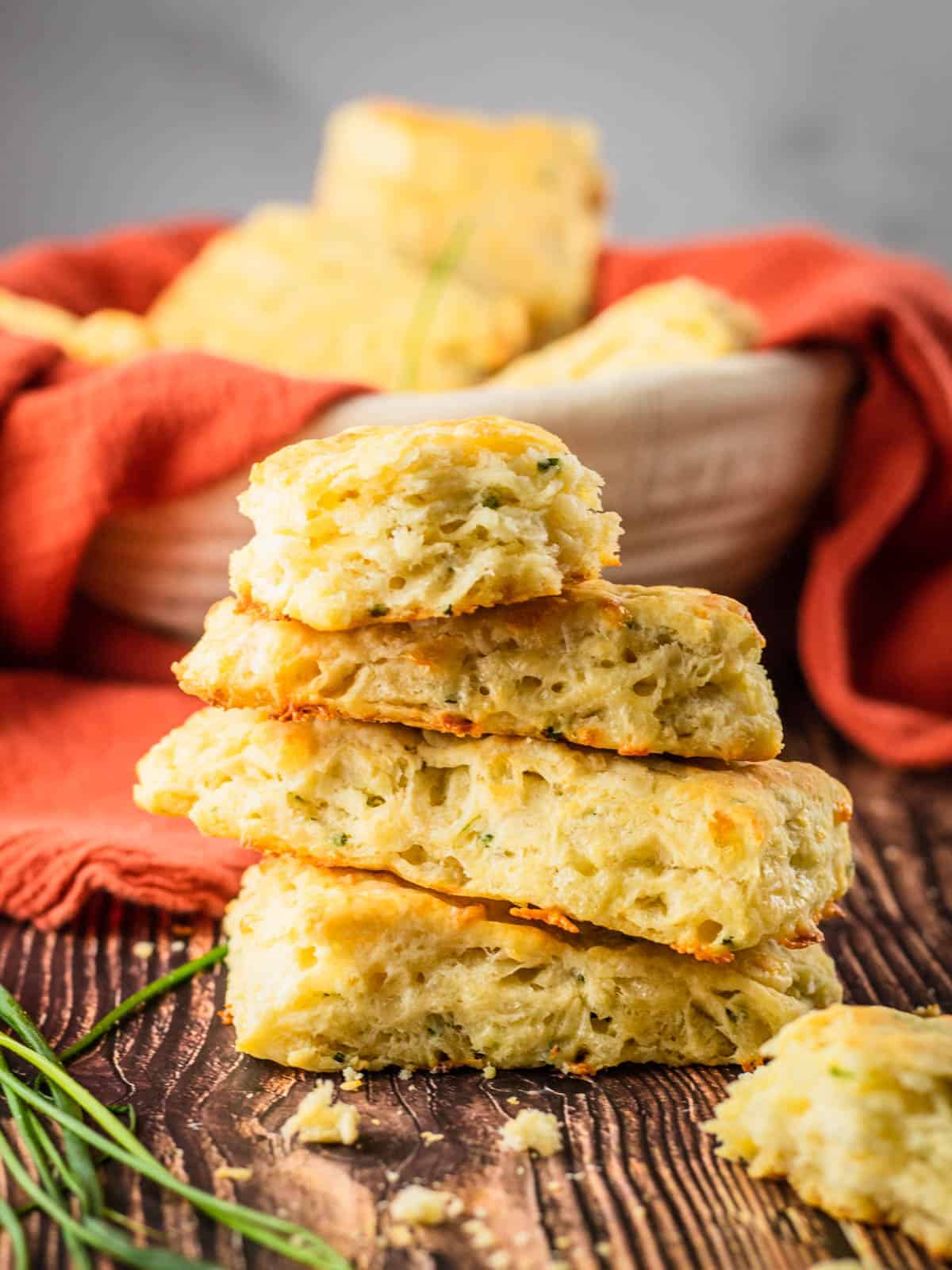 stack of rectangle shaped biscuits stacked on top of each other with fresh chives 