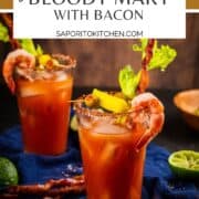 two bloody marys garnished with bacon, shrimp, celery, peppers and olives