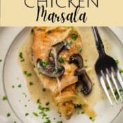 piece of chicken marsala on a white plate with mushrooms on top with a fork next to it