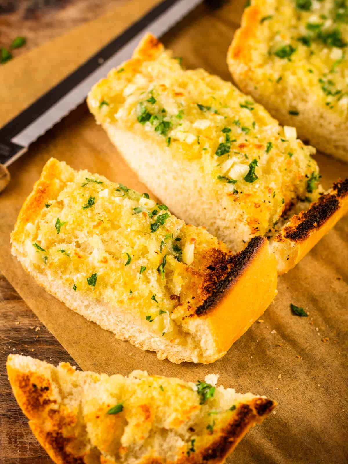 sliced toasted italian cheese bread with garlic and herbs on a sheet pan.