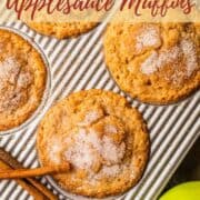 baked cinnamon sugar topped muffin in a pan with cinnamon sticks and apples.