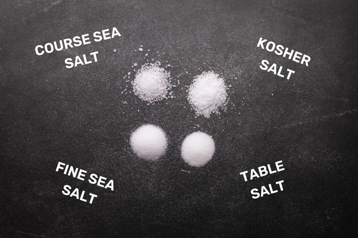 four piles of salt on a black table with word overlay of salt types.