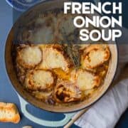 dutch oven of french onion soup topped with cheesy croutons.