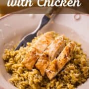 bowl of pesto orzo with sliced chicken and a fork.